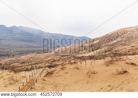 Sarykum Dune. Dagestan, Russia. A Unique Sandy Mountain In The Caucasus On A Cloudy Day. Grass Grows