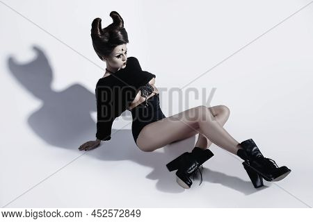 Model In Creative Image. Spooky Porcelain Doll With Horns On Her Head.
