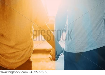 Couple Yellow And Blue Of Friends Standing Backs And Holding Hands To Meet The Light.