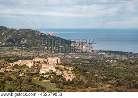 Hilltop Village Of Pigna In The Balagne Region Of Corsica With Mediterranean Sea In The Distance