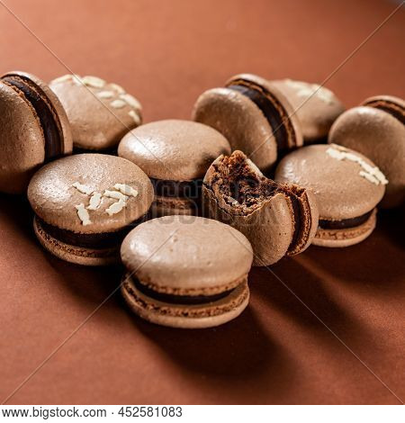 Some Tasty Brown Macarons Cakes Against A Monochromatic Brown Background.