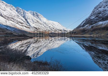 Beautiful Winter Landscape Image Of Loch Achtriochan In Scottish Highlands With Stunning Reflections