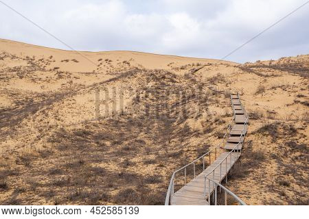 The Staircase Rises To A Sandy Dune. Climbing To The Top In The Desert. Sarykum Dune. Dagestan, Russ