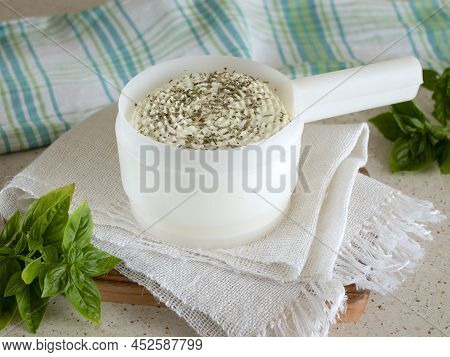 Round Cottage Cheese In A Cheese Making Mold With Dried Herbs And Fresh Basil, Selective Focus. Home