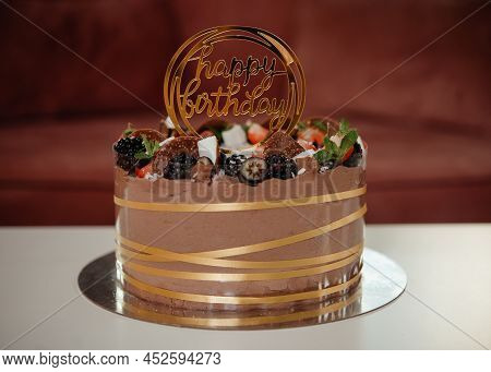 Chocolate Birthday Cake On A Table In Romm