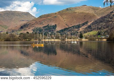 Tourists In A Rowing Boat On Grasmere Lake In The Lake District National Park