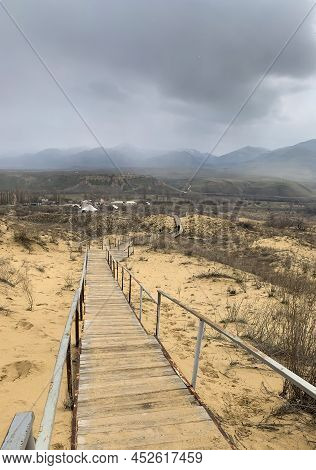 The Staircase Rises To A Sandy Dune. Climbing To The Top In The Desert. Sarykum Dune. Dagestan, Russ