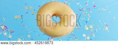 One Flying Sweet Doughnut In Glaze With Sprincles On Blue