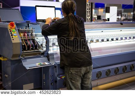 Industrial Technician Operating Wide Format Digital Inkjet Printer. Printing Industry.