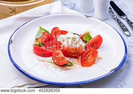 Salad With Buratta Cheese And Tomatoes On Bowl On Grey Table