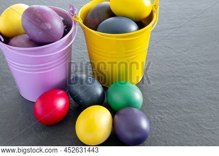 Lots Of Bird Bucket  With Painted Easter Eggs On A Dark Tabletop. Holiday Greeting Card. Concept Cre
