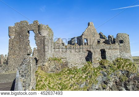 Bushmills, Northern Ireland, March 18, 2022.  The Exterior Of Dunluce Castle Ruins In A Sunny Day.
