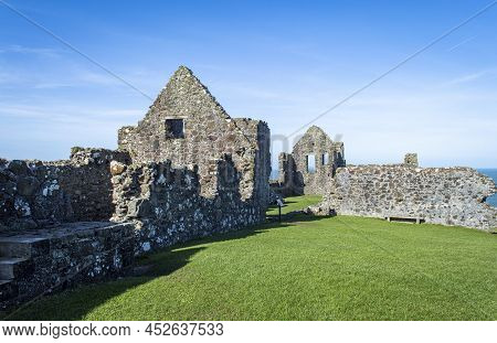 Bushmills, Northern Ireland, March 18, 2022. Dunluce Castle Ruins At Northern Ireland In A Sunny Day