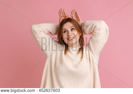 Portrait Of Blond Woman Making Funny Bunny Ears With Hands On Head, Childish Behavior, Playful Optim