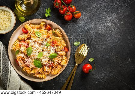 Italian Pasta Alla Arrabiata With Fresh Tomatoes, Basil And Parmesan On Black Stone Table. Flat Lay 