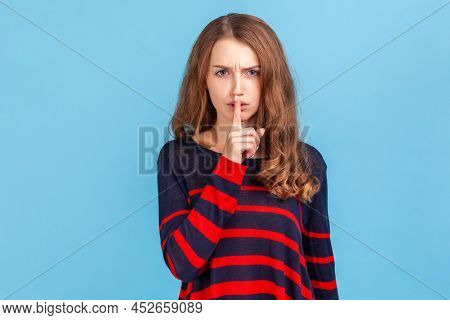 Keep Silence And Be Quiet. Woman Wearing Striped Casual Style Sweater Looking Angrily And Holding Fi