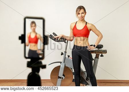 Attractive Woman Fitness Instructor In Sports Tights And Top Broadcasting Livestream, Using Phone Ca