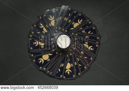 Tarot Cards And Burning Candle On Black Table, Flat Lay. Reverse Side