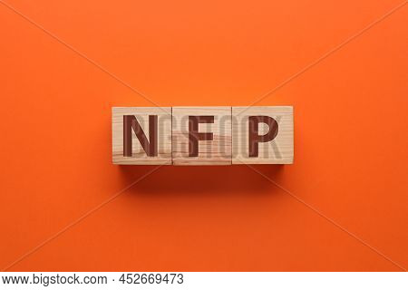 Abbreviation Nfp (nonfarm Payroll) Made With Wooden Cubes On Orange Background, Flat Lay