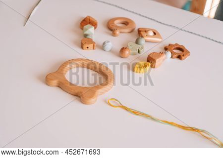 Natural Safe Accessories Of Wood On Desk, Eco Style Pacifiers. Ecological Teether Toy With Trinket R