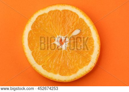 Round Slice Of Orange With Pit On Orange Background