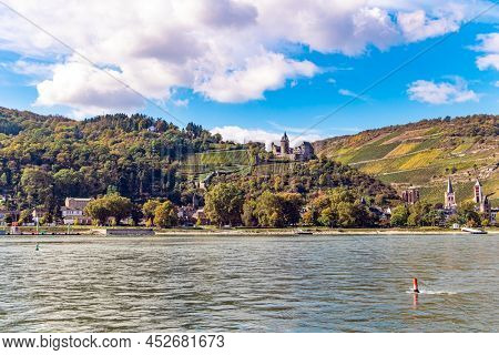 Medieval knight's castles and ruins. Warm autumn in Germany. Beautiful wooded slopes of the coastal hills of the river Rhine. Castle Stahleck stands on a ledge of a mountain slope