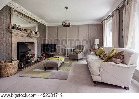 Fen Drayton, England - June 7 2018: Furnished Grand Sitting Room With Stone Fireplace And Panelled W