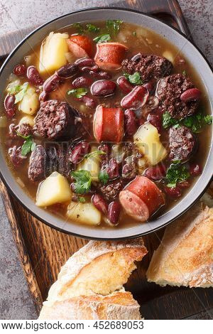 Hearty Portuguese Stone Soup Served With Bread Closeup In The Plate On The Table. Vertical Top View 