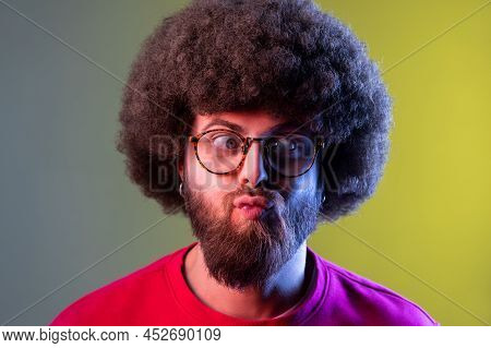 Portrait Of Crazy Hipster Man With Afro Hairstyle Standing With Crossed Eyes And Looking With Funny 