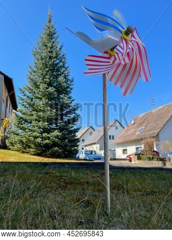 Colorful Pinwheel With Houses In The Background