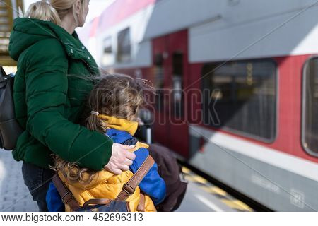 Ukrainian Woman With Daughter Saying Good Bye And Waving To His Family In Train Leaving Ukraine Due 