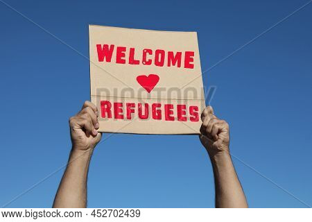 Man Holding Poster With Phrase Welcome Refugees Outdoors, Closeup