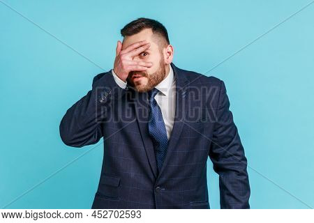 Bearded Handsome Man Wearing Official Style Suit Looking Through Fingers, Peeking With Curious Face,