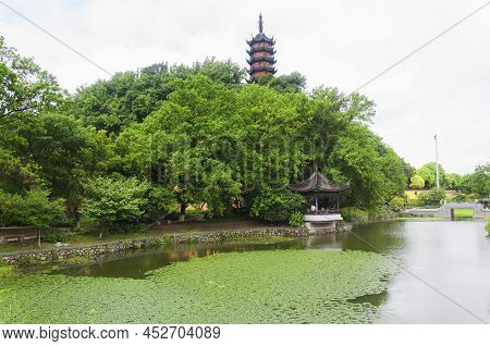 Zhenjiang, China. August 12, 2017. Cishou Pagoda On A Hill Above A Lily Filled Pond Within The Jinsh