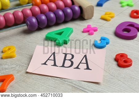 Paper Sheet With Abbreviation Aba (applied Behavior Analysis), Abacus And Colorful Numbers On White 
