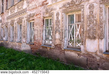 A House With Stucco Molding, A Shabby, Rough Cracked Wall, Windows Taped With Duct Tape. The Concept