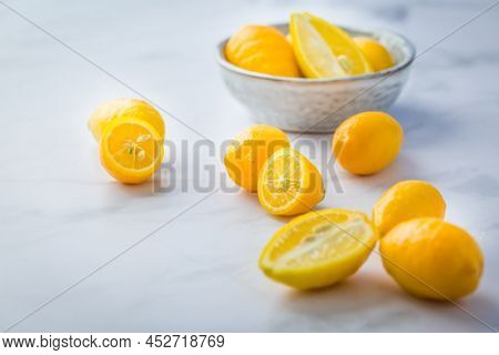 Small citrus fruits limequat with bowl on table