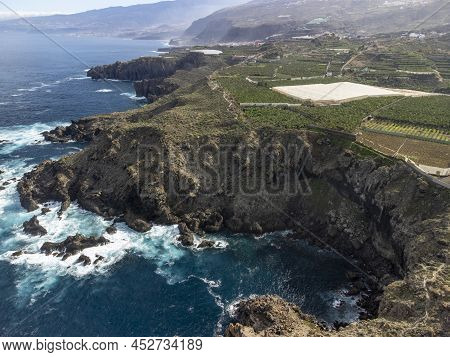 Aerial View On Charco Del Viento Natural Pool In Black Lava Rocks And Banana Tree Plantation On Tene