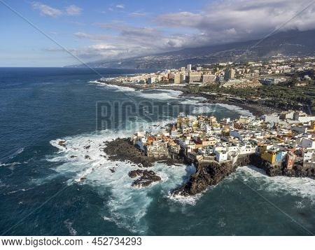 Aerial View On Colorful Houses And Black Lava Rocks In Small Village Punta Brava Near Puerto De La C
