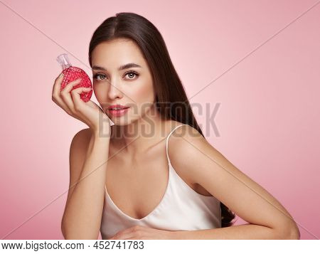 Young Beautiful Woman With A Bottle Of Perfume. Model With Healthy Skin, Close Up Portrait. Cosmetol