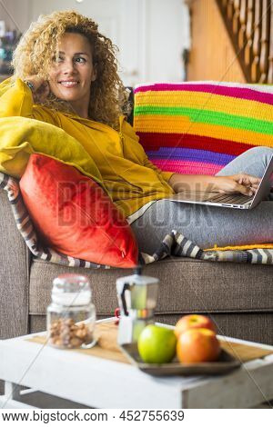 Beautiful Young Middle Age Woman Enjoy Home And Work With Laptop Computer On The Sofa In Morning Bre