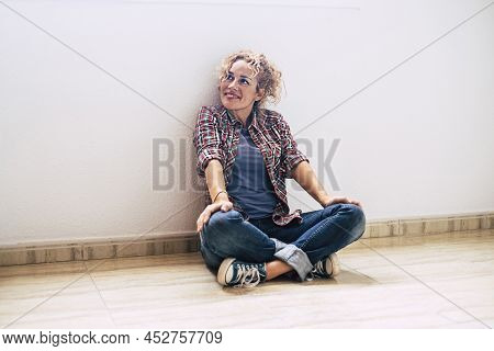 Happy Single Adult Woman Sit Down On The Floor Of Empty New House Property - Female Lady Smile And L