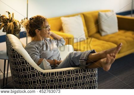 One Woman Sitting On The Chair At Home With Legs Up And Barefoot Comfort. Female People At Home In L