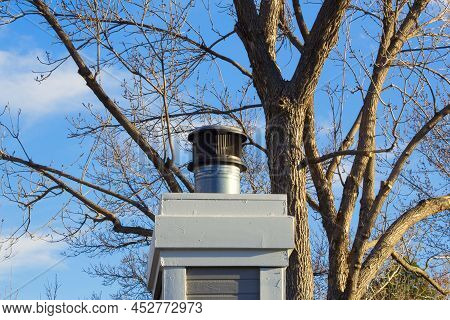 Chimney Fireplace Roof House Ventilation Against Blue Sky With Clouds And Spring Trees Natural Backg