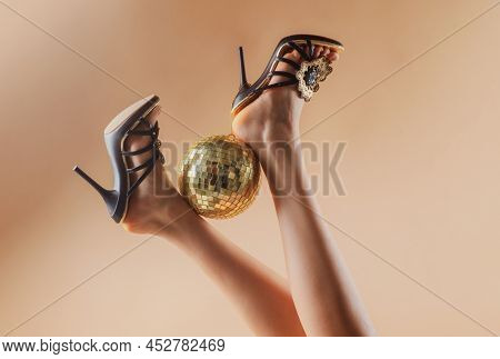Gold Disco Ball On High Heels. Sexy Legs. Disco Party. Woman Legs With Gold Disco Ball. Celebrate Co