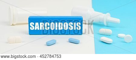 Medical Concept. On A White And Blue Surface Are Pills, A Spray And A Wooden Sign With The Inscripti