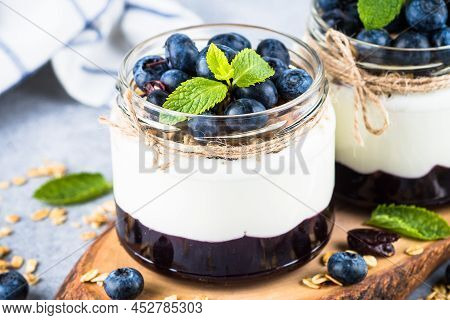 Parfait With Blueberry And Jam In Glass Jars At Light Background. Healthy Dessert Or Snack.