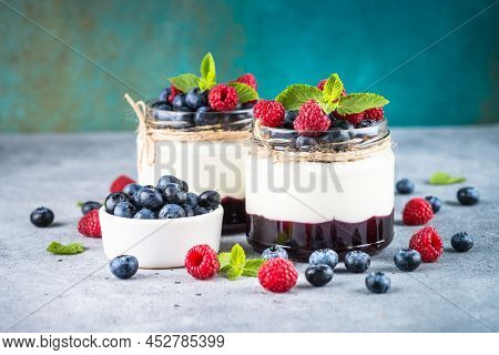 Parfait With Cream Or Yogurt, Jam And Fresh Berries In The Glass Jar. Close Up. Healthy Dessert Or S