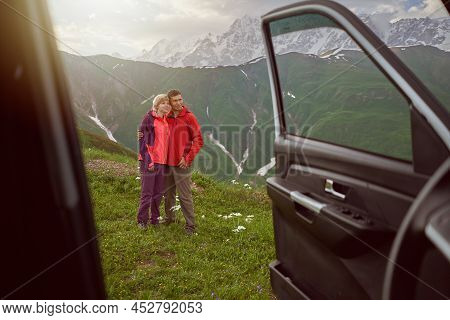 Happy Couple Hugs On Beautiful Nature Mountains Area Out Of Car