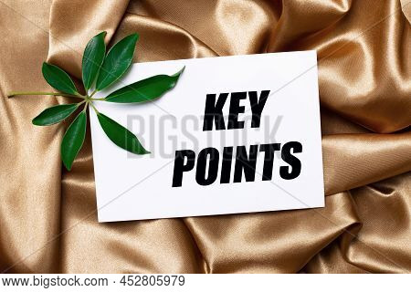 On Beautifully Curved Golden Silk Lies A Shefflera Sheet And A White Card With The Text Key Points